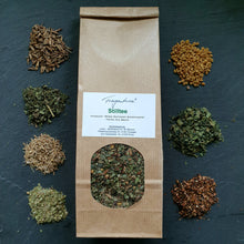 Lade das Bild in den Galerie-Viewer, Fragantura Stilltee in brauner Papiertüte, umgeben von kleinen Häufchen der einzelnen Kräuterzutaten, dekorativ auf dunklem Untergrund arrangiert.