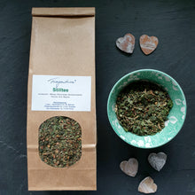Lade das Bild in den Galerie-Viewer, Fragantura Stilltee in brauner Papiertüte mit Sichtfenster und grün gemusterter Schale mit losem Tee, daneben kleine Deko-Herzen.