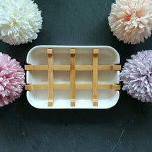 Lade das Bild in den Galerie-Viewer, Leere, weiße Seifenschale mit Bambuseinsatz, dekorativ von vier pastellfarbenen Blumen umrahmt.