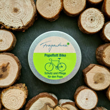 Lade das Bild in den Galerie-Viewer, Das Bild zeigt eine geschlossene Metalldose Popoflott Bike von Fragantura mit grünem Etikett und Fahrradsymbol. Die Dose ist von Baumscheiben umrahmt auf dunklem Untergrund.