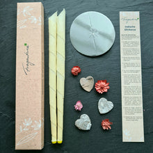 Lade das Bild in den Galerie-Viewer, Zwei gelbe Fragantura Ohrenkerzen mit Metallschutz, Anleitung und Herzdeko auf dunklem Stein.