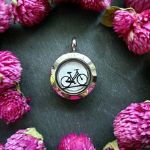 Lade das Bild in den Galerie-Viewer, Runder Duftanhänger mit schwarzem Fahrradsymbol auf weißem Filz, eingerahmt von pinken Trockenblumen