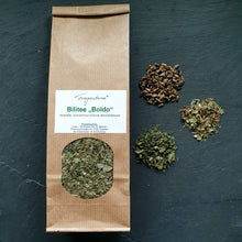 Lade das Bild in den Galerie-Viewer, Tüte „Bilitee-Boldo“ mittig auf dunklem Hintergrund, umgeben von den losen Zutaten: Boldoblätter, Löwenzahnkraut und Mariendiestelfrüchte. Die Zutaten des Tees sind in der Sichtöffnung der Tüte gut erkennbar.