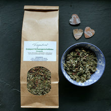 Lade das Bild in den Galerie-Viewer, Produktfoto mit Papiertüte "Endspurt Schwangerschaftstee" und Schale mit Teekräutern, daneben drei kleine Holzherzen auf Schieferplatte arrangiert.
