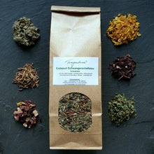 Lade das Bild in den Galerie-Viewer, Braune Papiertüte mit Sichtfenster und Etikett "Endspurt Schwangerschaftstee – Kräutertee", mittig auf schwarzem Untergrund platziert. Rundherum liegen die erkennbaren Teezutaten in kleinen Häufchen verteilt: Himbeerblätter, Ringelblumen, Hibiskusblüten, Brennnesselblätter, Fenchelsamen und getrocknete Mango-Ananas-Stücke.