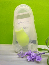 Lade das Bild in den Galerie-Viewer, Transparente Kunststoffbox mit einem grünen Nasensauger-Set der Lilien Apotheke. Der Sauger mit flexiblem Schlauch ist sichtbar in der Box verstaut. Im Hintergrund ein grüner Wandhintergrund, im Vordergrund eine Lavendel-Dekoblume auf hellem Untergrund.
