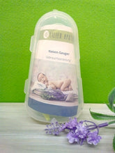 Lade das Bild in den Galerie-Viewer, Transparente Kunststoffbox mit beiliegender Gebrauchsanleitung für einen Nasensauger der Lilien Apotheke. Auf der Anleitung ist ein schlafendes Baby auf einer Decke mit Lavendelblüten abgebildet. Im Vordergrund liegt ein künstlicher Lavendelzweig. Hintergrund: grüne Wand und helle Holzfläche.