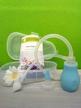 Lade das Bild in den Galerie-Viewer, Nasensauger-Set in transparenter Kunststoffbox mit geöffneter Klappe. Enthalten ist ein blauer Nasensauger mit Pumpball, flexiblem Schlauch und Aufsatz. Im Hintergrund liegt die Gebrauchsanleitung der Lilien Apotheke mit einem Bild eines schlafenden Babys. Links im Bild eine weiße Dekoblume, Hintergrund ist eine grüne Wand.