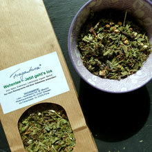 Lade das Bild in den Galerie-Viewer, Links ist ein Ausschnitt der braunen Teeverpackung mit Etikett und Sichtfenster sichtbar, rechts daneben eine violette Schale mit dem losen Kräutertee in Nahaufnahme. Einzelne Bestandteile wie getrocknete Blätter und Rindenstücke sind gut erkennbar. Der Hintergrund bleibt dunkel und dekorativ.